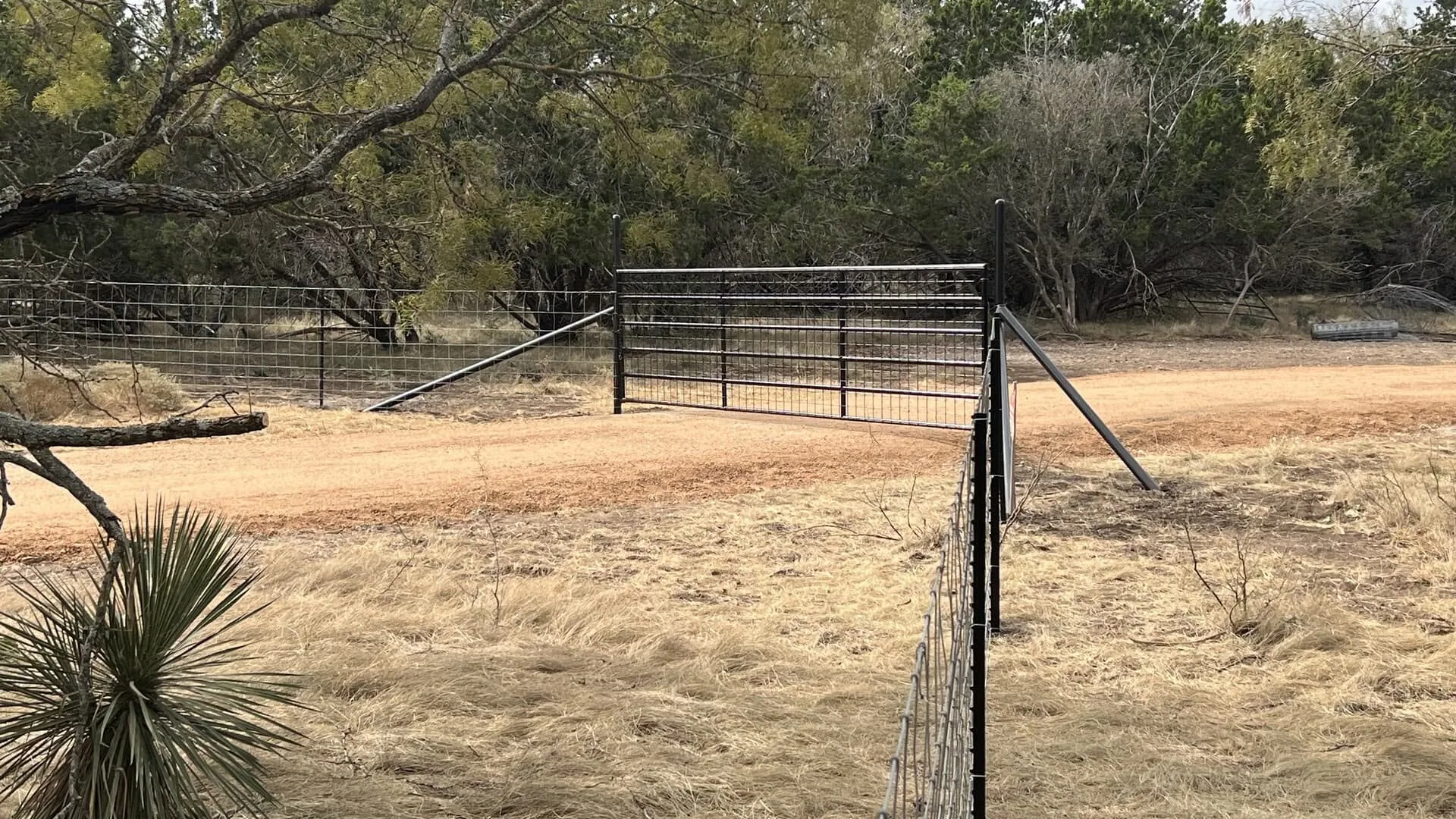 Black pipe ranch entry gate welded wire fence