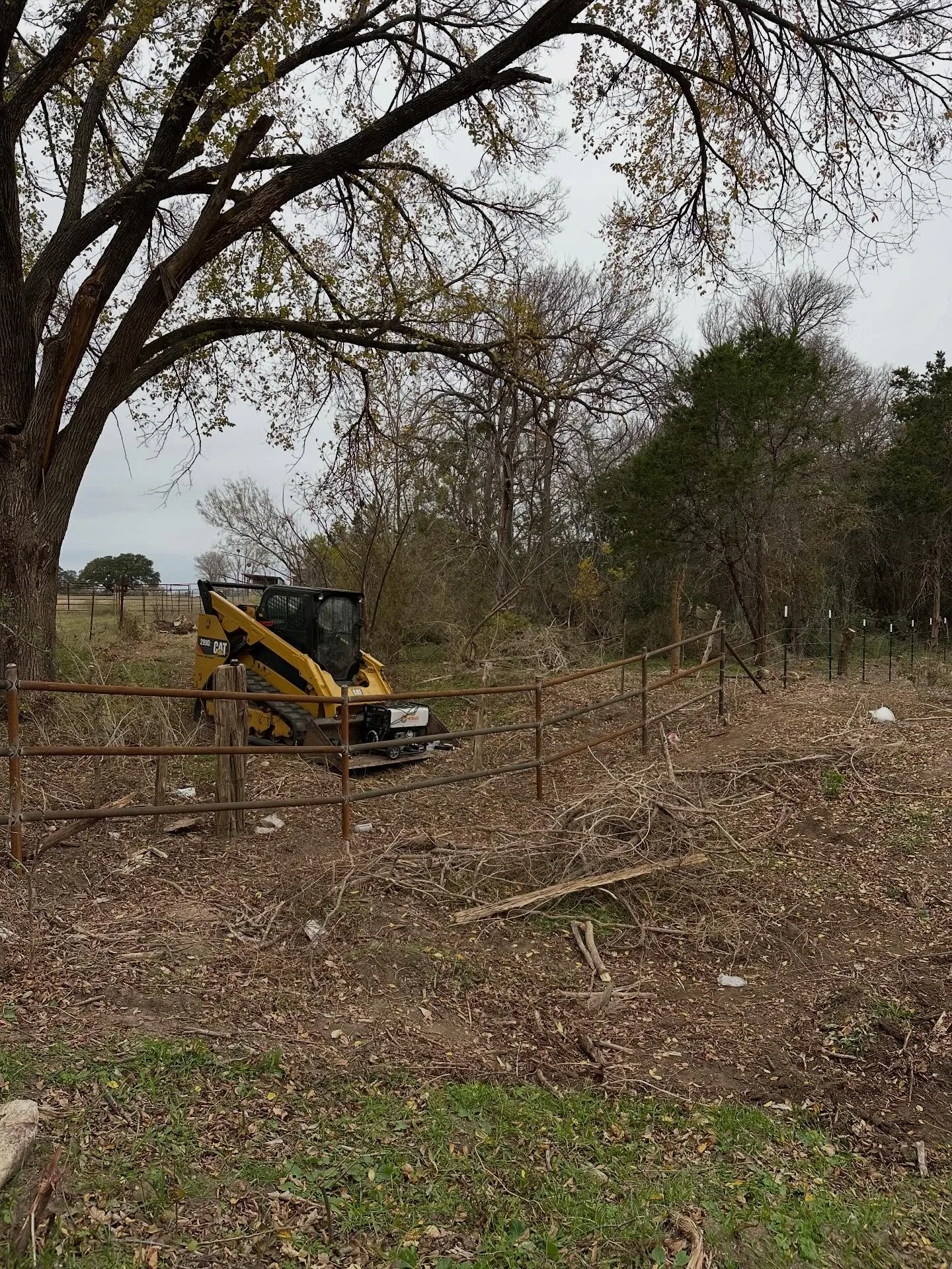 Compact track loader fence line brush clearing pipe rail