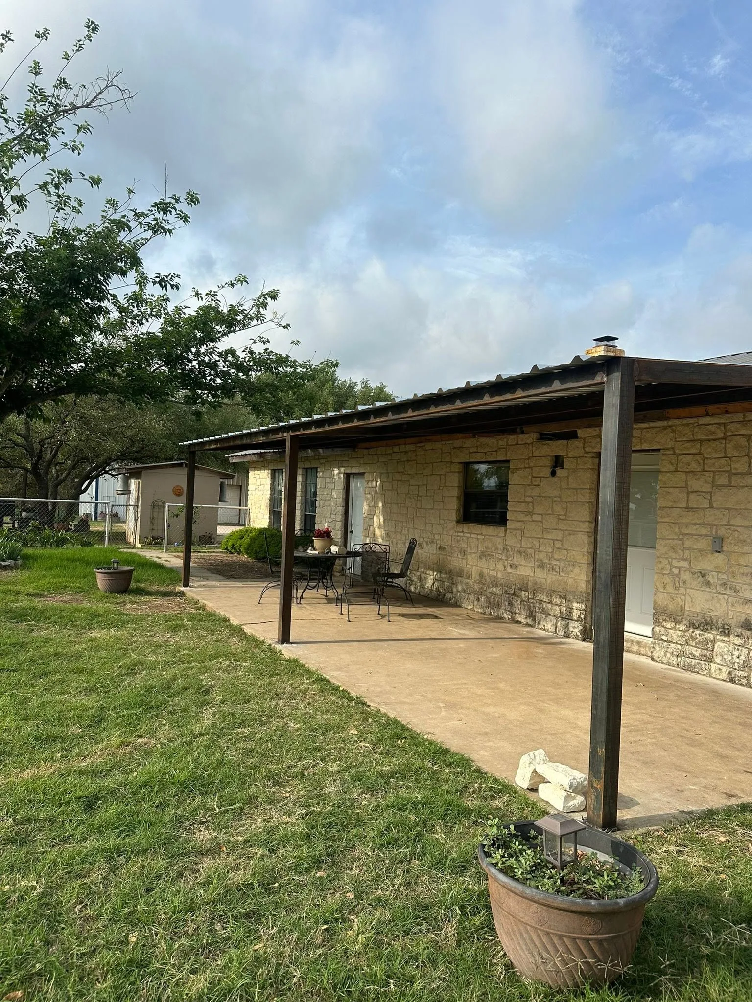 Limestone ranch house metal roof patio cover steel posts