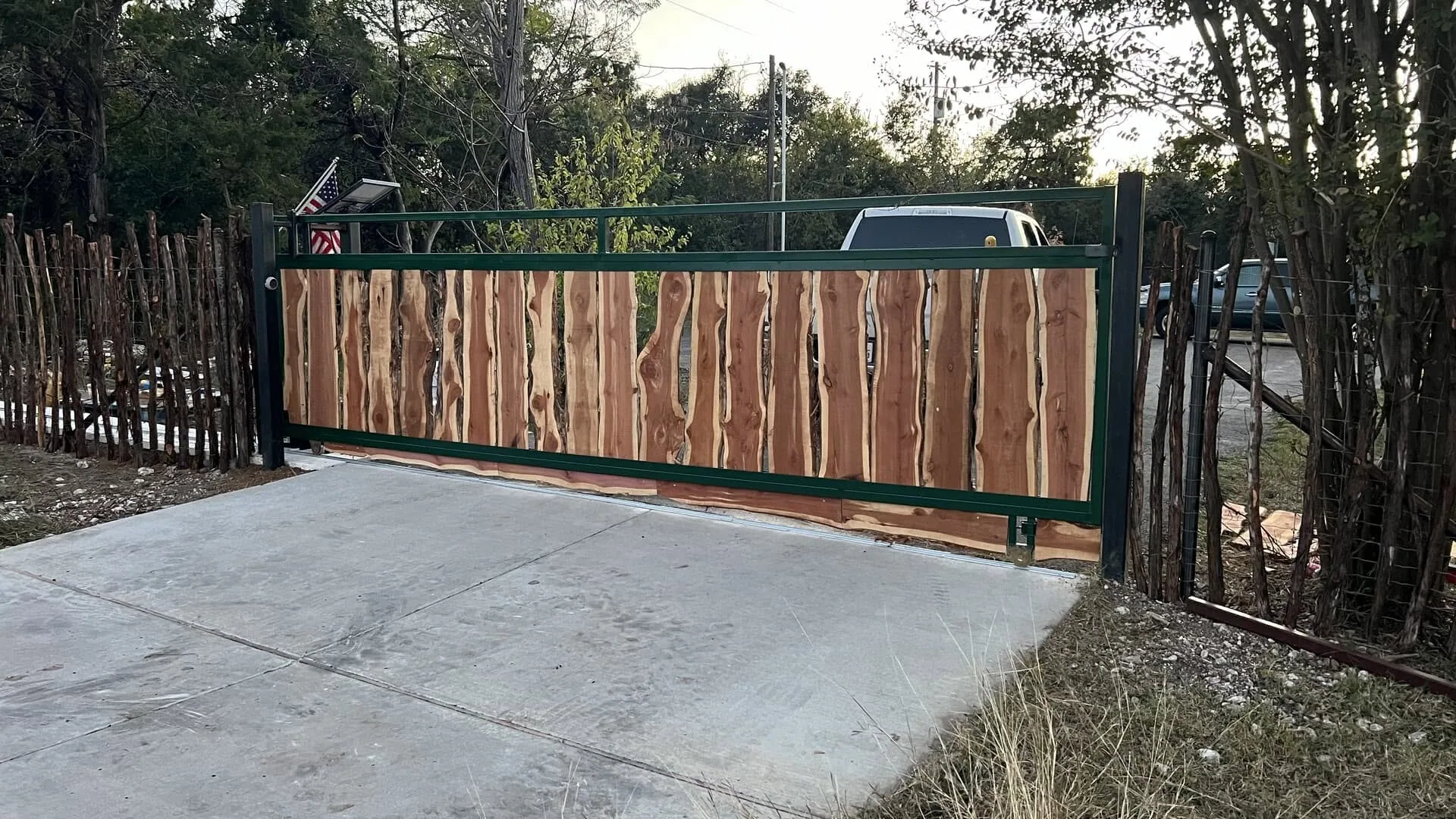 Live edge cedar slab driveway gate green steel frame hill country