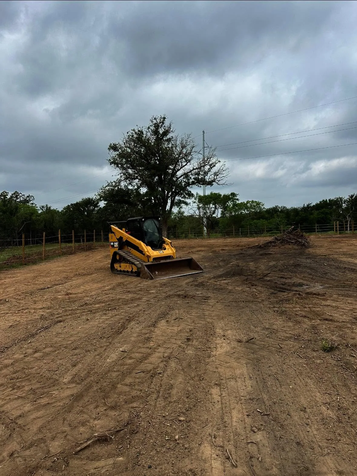 Track loader lot clearing brush pile fence line